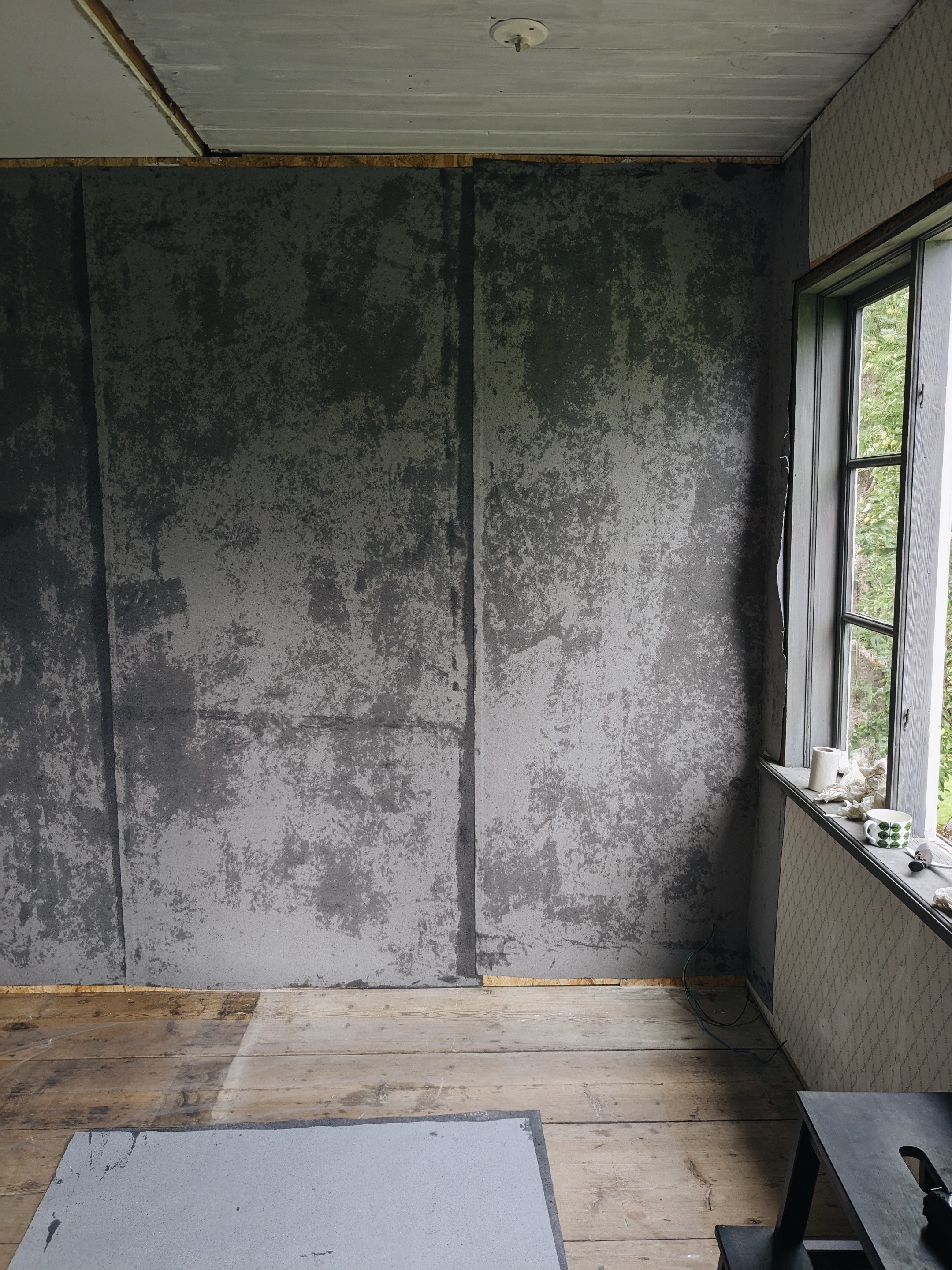 Vägg täckt med lumppapp i grå ton